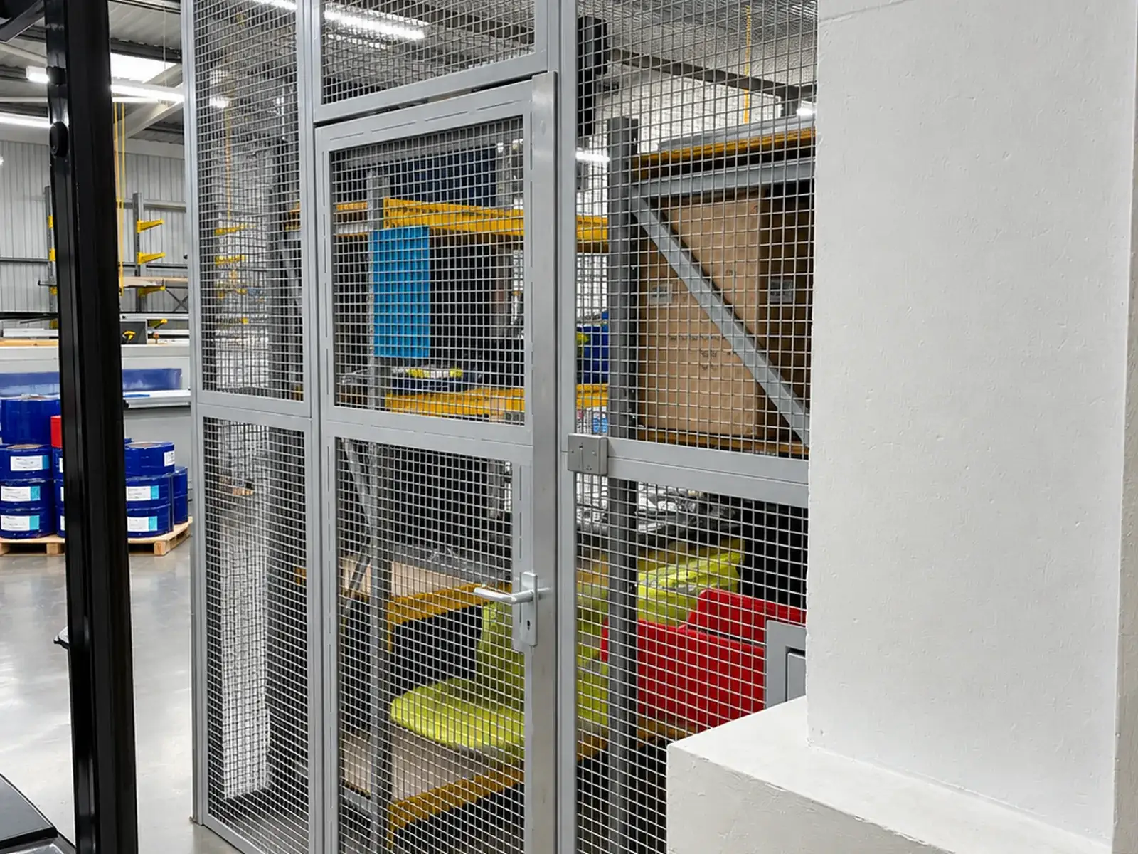 Mesh security cage with a hinged door and fixed overhead panel, sized to fit the bay