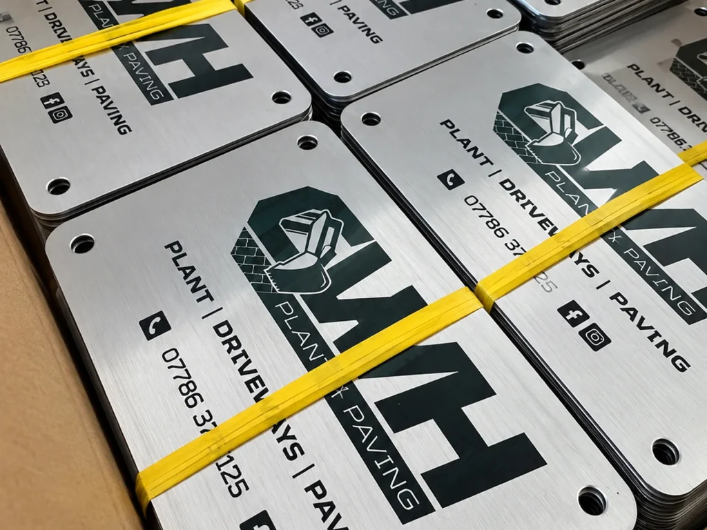Brushed stainless steel plaques laser marked with a company logo and contact details